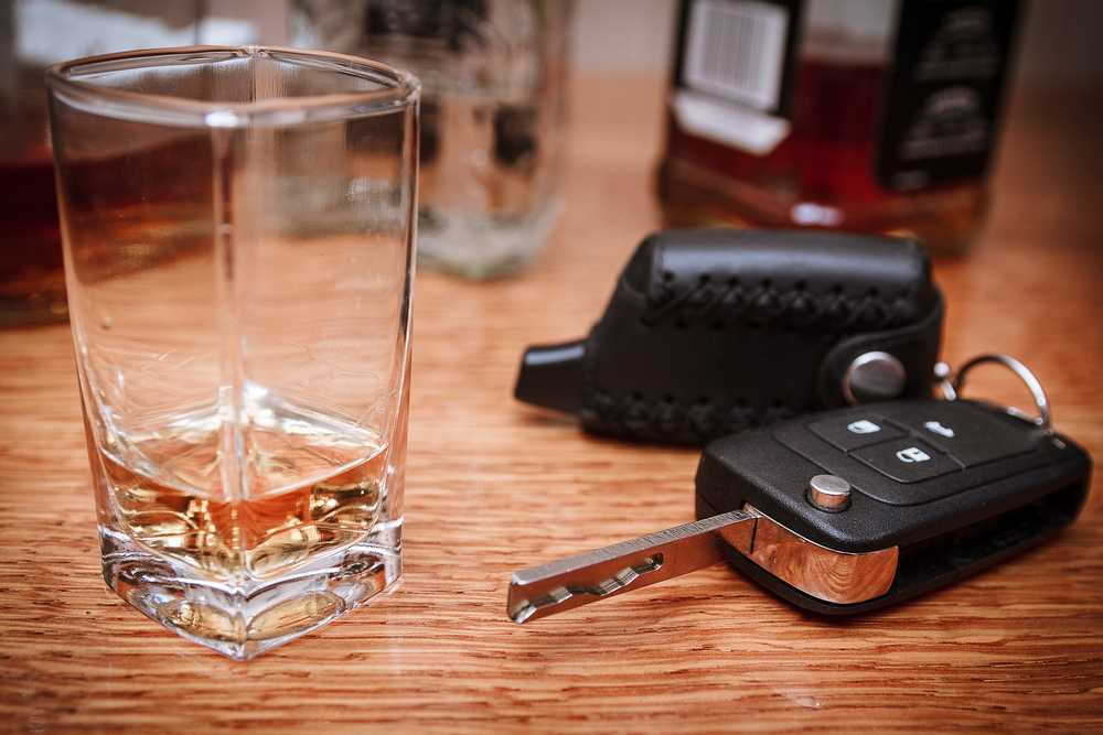 Shot glass with car keys and handcuffs